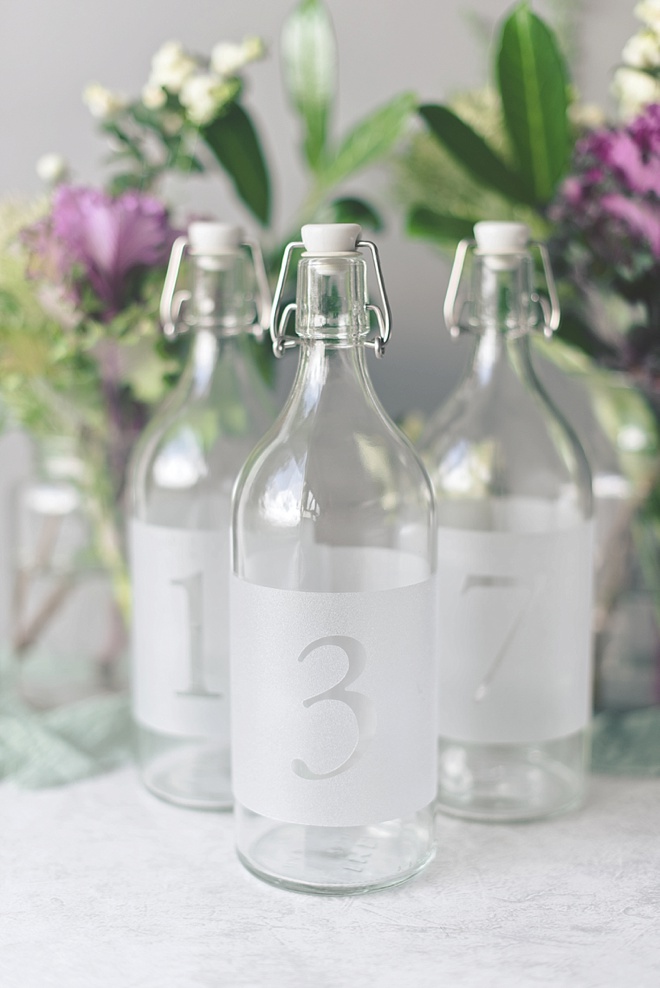 Frosted carafe glass bottles for wedding table numbers